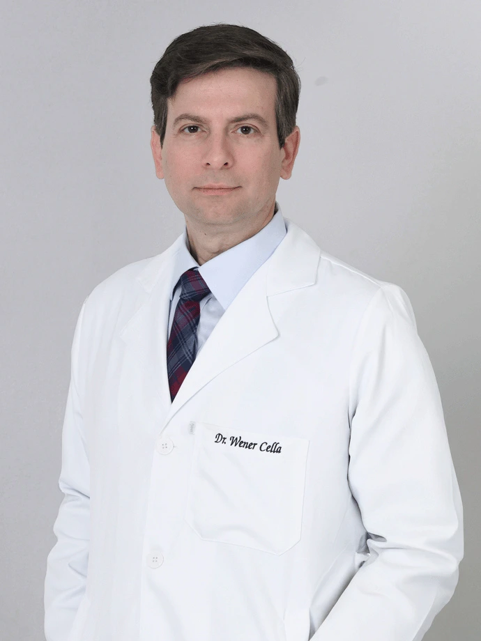 Retrato do Dr. Wener Cella, oftalmologista especialista em retina em São Luís, de jaleco branco sobre fundo cinza